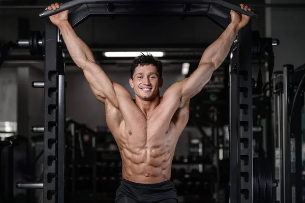 Stilig bodybuilder träning i gym sexig man lyft hantlar — Stockfoto