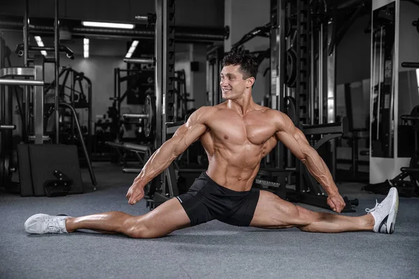Splits stretches man stretching legs in the gym handsome fitness — Stock Photo, Image