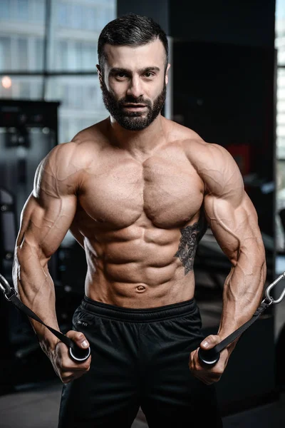 Инструктор по фитнесу красивый мужчина в спортзале набирает мускулы — стоковое фото