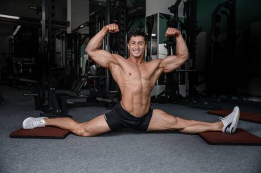 Bölmeleri uzanıyor adam spor salonu yakışıklı fitness bacak germe