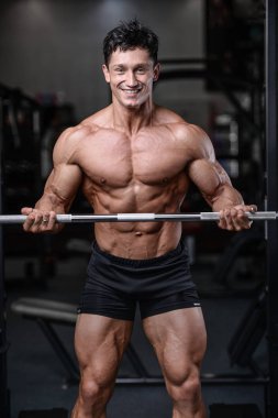 Spor salonu seksi adam Asansör dumbbells eğitim yakışıklı vücut geliştirmeci