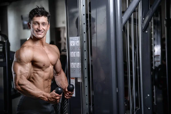 Spor salonu seksi adam Asansör dumbbells eğitim yakışıklı vücut geliştirmeci