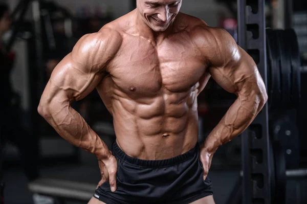 Handsome bodybuilder training in the gym sexy man lift dumbbells — Stock Photo, Image