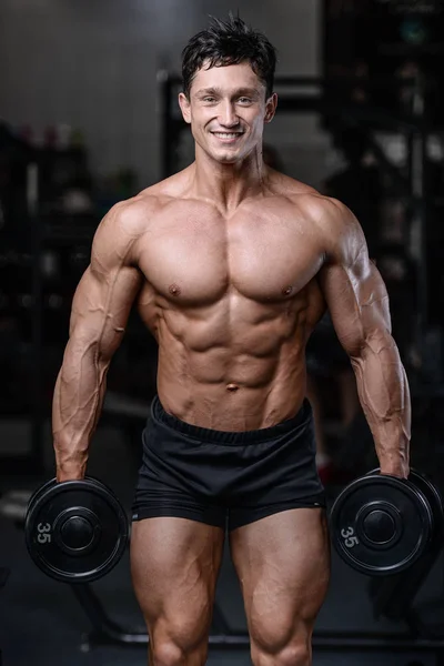 Spor salonu seksi adam Asansör dumbbells eğitim yakışıklı vücut geliştirmeci — Stok fotoğraf