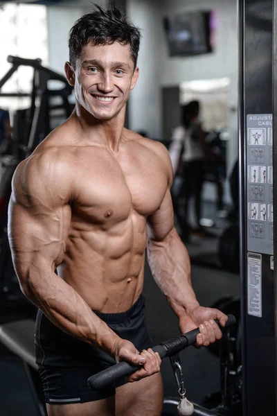Bello bodybuilder formazione in palestra sexy uomo sollevare i manubri — Foto Stock