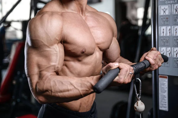 Handsome bodybuilder training in the gym sexy man lift dumbbells — Stock Photo, Image