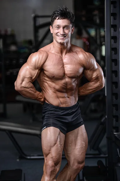 Handsome bodybuilder training in the gym sexy man lift dumbbells — Stock Photo, Image