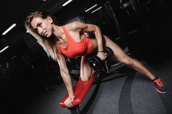 Mujer joven atlética posando y ejercitando ejercicio físico con —  Fotos de Stock