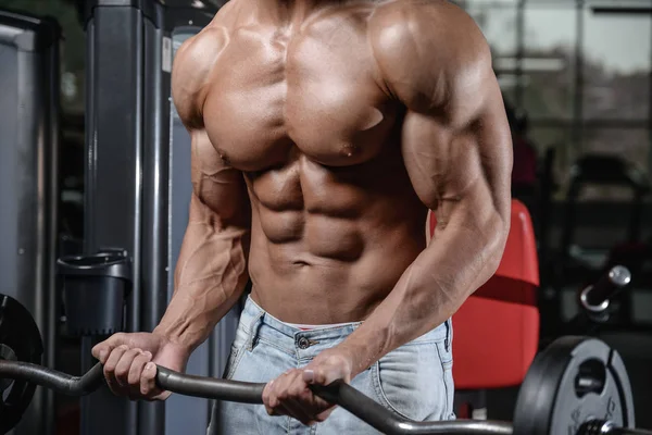 Nära håll stark abs kille visar i gym musklerna — Stockfoto