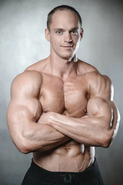 Brutale starke Bodybuilder Mann posiert im Studio auf grauem Hintergrund — Stockfoto