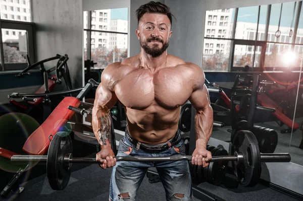 Brutal fuerte culturista hombre bombeando los músculos y entrenar gimnasio —  Fotos de Stock
