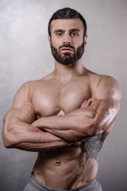 Acımasız güçlü vücut geliştirmeci adam gri adam Studio'yu poz