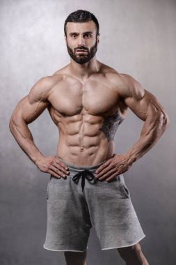 Acımasız güçlü vücut geliştirmeci adam gri adam Studio'yu poz