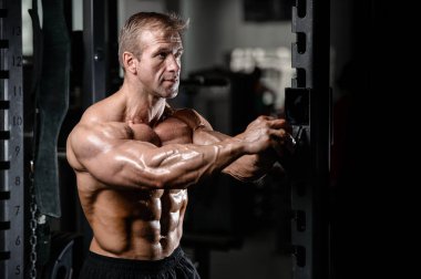 Kas ve tren spor salonu kadar pompalama acımasız güçlü vücut geliştirmeci adam