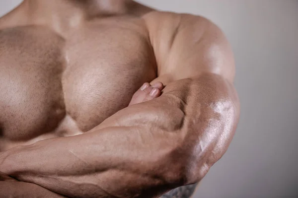 Brutal fuerte culturista hombre posando en estudio sobre fondo gris — Foto de Stock