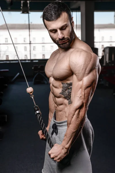 Handsome fitness model train in the gym gain muscl