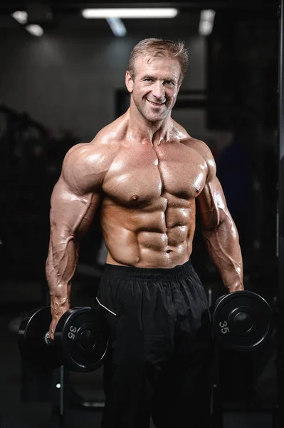 Brutaler starker Bodybuilder, der Muskeln aufpumpt und Fitnessstudio trainiert — Stockfoto