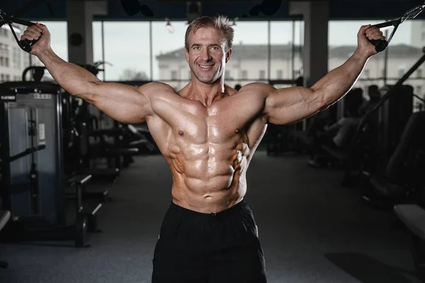 Brutaler starker Bodybuilder, der Muskeln aufpumpt und Fitnessstudio trainiert — Stockfoto