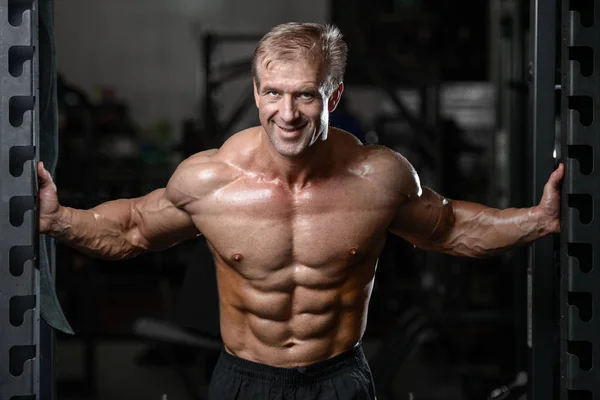 Kas ve tren spor salonu kadar pompalama acımasız güçlü vücut geliştirmeci adam — Stok fotoğraf