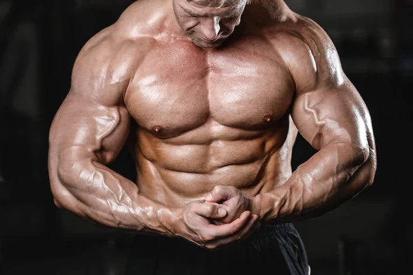 Brutal fuerte culturista hombre bombeando los músculos y entrenar gimnasio —  Fotos de Stock