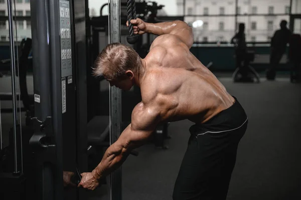 Brutal fuerte culturista hombre bombeando los músculos y entrenar gimnasio —  Fotos de Stock