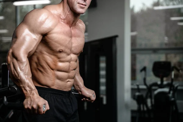 Brutal fuerte culturista hombre bombeando los músculos y entrenar gimnasio —  Fotos de Stock