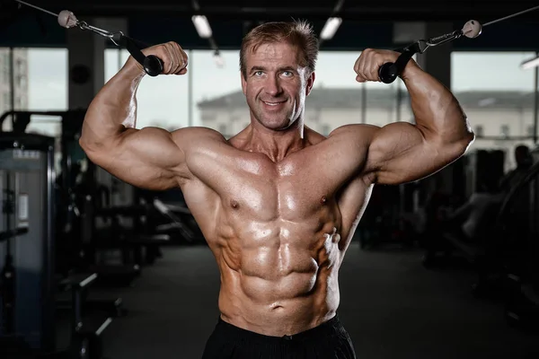 Brutaler starker Bodybuilder, der Muskeln aufpumpt und Fitnessstudio trainiert — Stockfoto