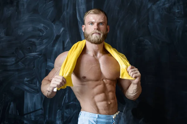 Brutal forte bodybuilder uomo in posa in studio su backgroun grigio — Foto Stock