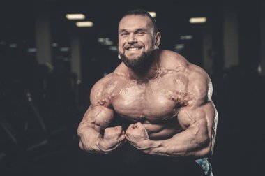 Yakışıklı uygun beyaz kas adam kasları spor salonunda esneme