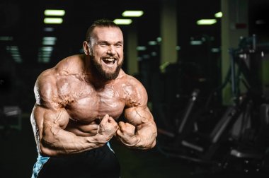 Yakışıklı uygun beyaz kas adam kasları spor salonunda esneme