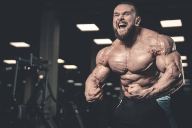 Yakışıklı uygun beyaz kas adam kasları spor salonunda esneme