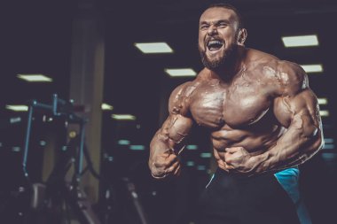 Yakışıklı uygun beyaz kas adam kasları spor salonunda esneme