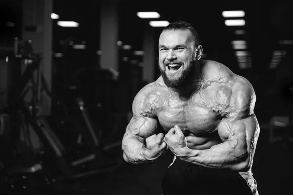 Handsome fit caucasian muscular man flexing his muscles in gym — Stock Photo, Image