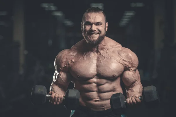 Gutaussehender Kraftsportler beim Diättraining, das Muskeln aufpumpt — Stockfoto