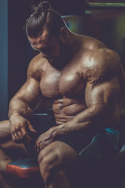 Knappe fit Kaukasische gespierde man die buigen zijn spieren in sportschool — Stockfoto