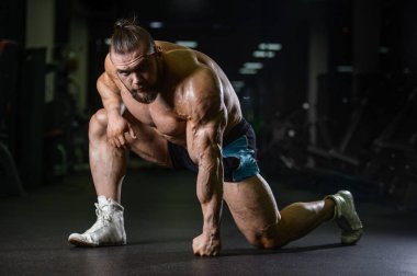 Yakışıklı uygun beyaz kas adam kasları spor salonunda esneme