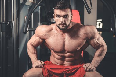 Yakışıklı uygun beyaz kas adam kasları spor salonunda esneme