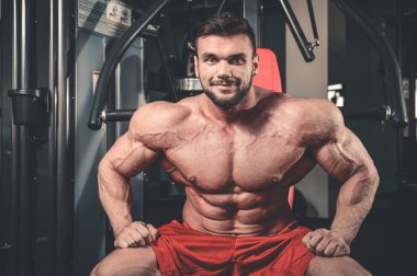 Yakışıklı uygun beyaz kas adam kasları spor salonunda esneme