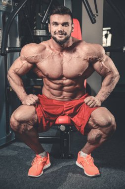 Yakışıklı uygun beyaz kas adam kasları spor salonunda esneme