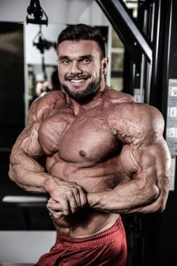 Yakışıklı uygun beyaz kas adam kasları spor salonunda esneme