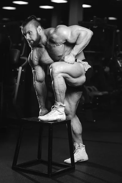Schöner fitter kaukasischer muskulöser Mann, der seine Muskeln im Fitnessstudio spielen lässt — Stockfoto