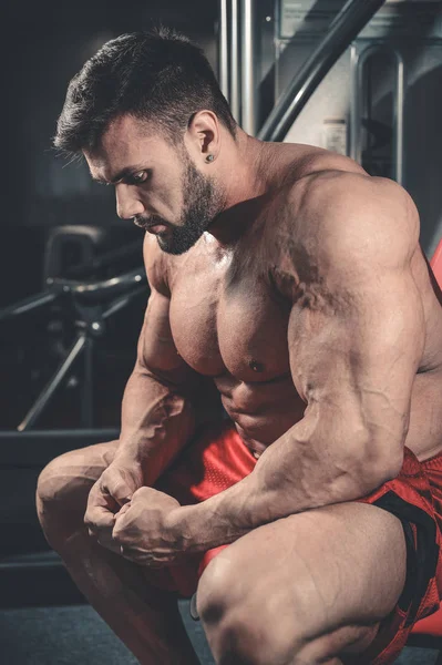 Knappe fit Kaukasische gespierde man die buigen zijn spieren in sportschool — Stockfoto