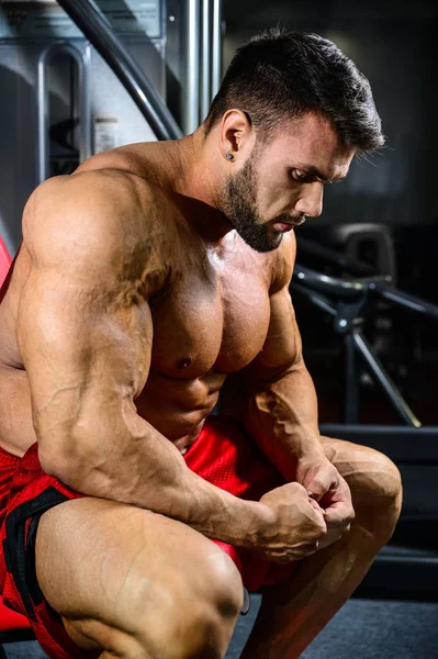 Przystojny sprawny kaukaski mięśni mężczyzna jego muskuły w siłowni — Zdjęcie stockowe
