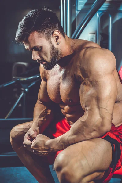 Красивый кавказский мускулистый мужчина, разминающий мышцы в спортзале. — стоковое фото