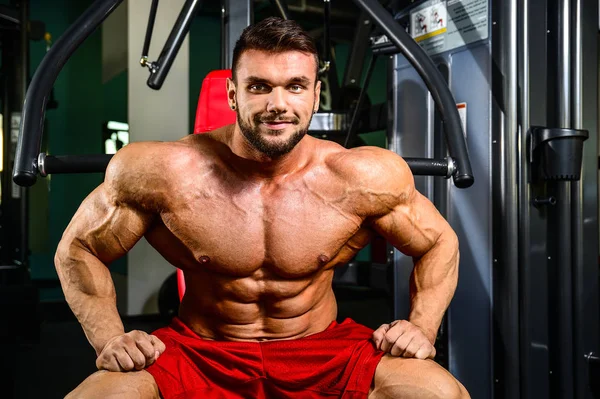 Bel ajustement caucasien musclé homme fléchissant ses muscles dans la salle de gym — Photo