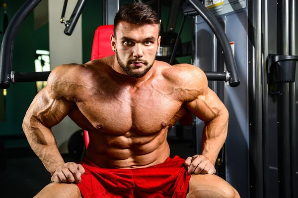 Guapo ajuste caucásico muscular hombre flexing su músculos en gimnasio — Foto de Stock