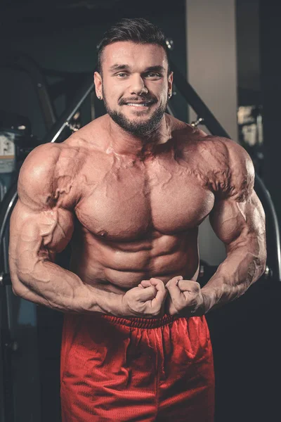 Bonito homem atlético poder no treinamento de dieta bombeando os músculos — Fotografia de Stock