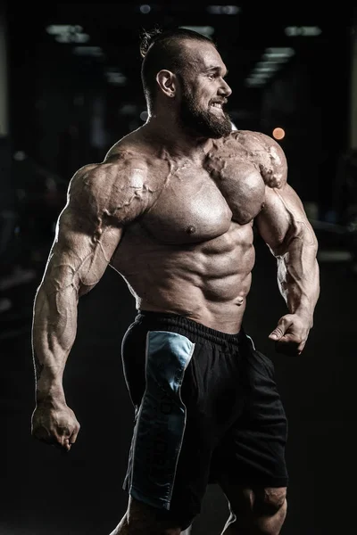 Handsome fit caucasian muscular man flexing his muscles in gym — Stock Photo, Image