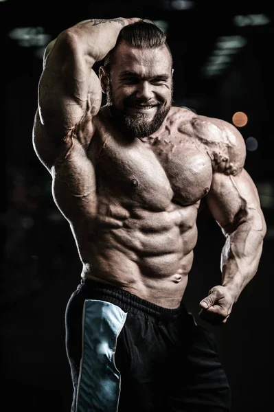 Handsome fit caucasian muscular man flexing his muscles in gym — Stock Photo, Image