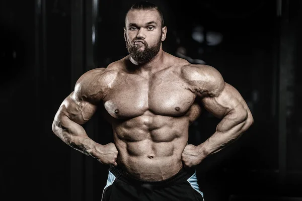 Handsome fit caucasian muscular man flexing his muscles in gym — Stock Photo, Image